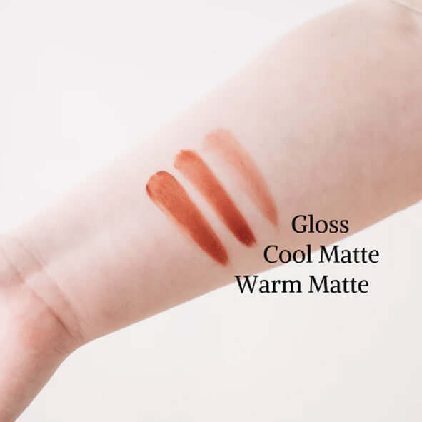3 tones of all natural lip tints on someone's arm. Gloss, warm matte and cool matte.