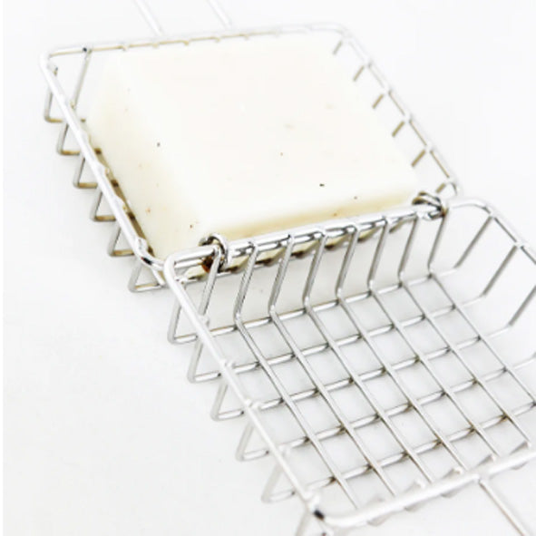 Stainless Steel soap cage open with a naked soap bar inside. Diminish.