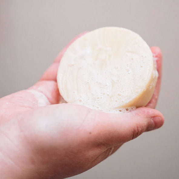 Plastic-free shampoo bar with suds in someone's hand. Adelaide Eco Shop.