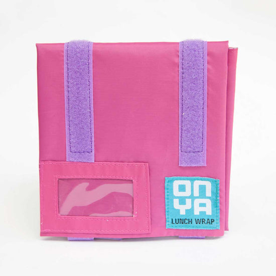 Load image into Gallery viewer, 1 pink reusable lunch wrap folded into a square with purple velcro and a clear screen for names. On a white background.
