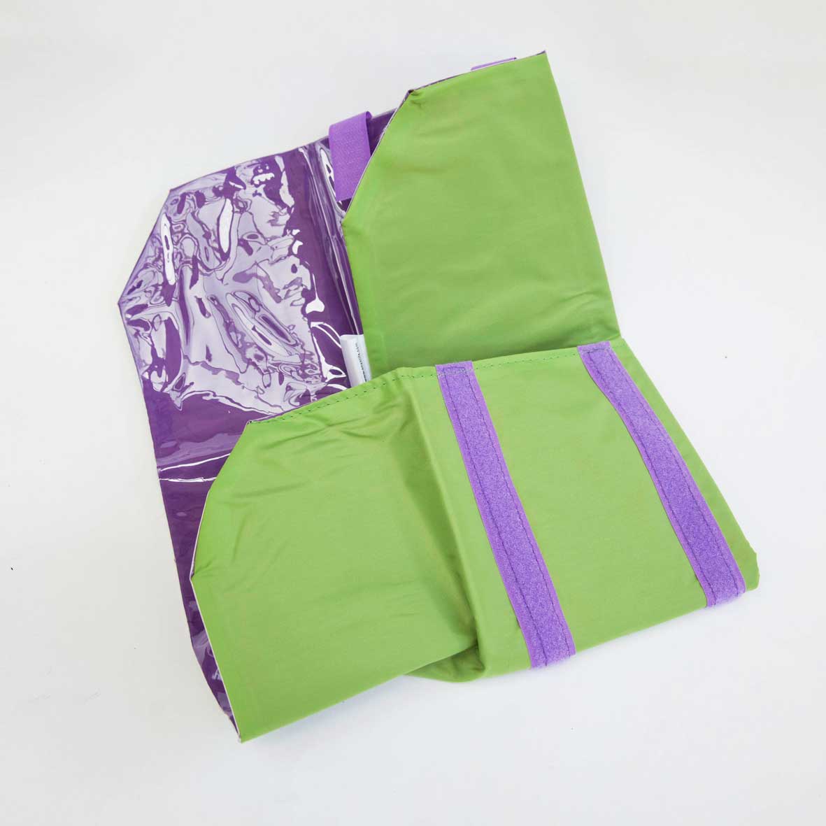 Load image into Gallery viewer, 1 Reusable green food wrap half folded up. With purple inside and purple velcro. On a white background.

