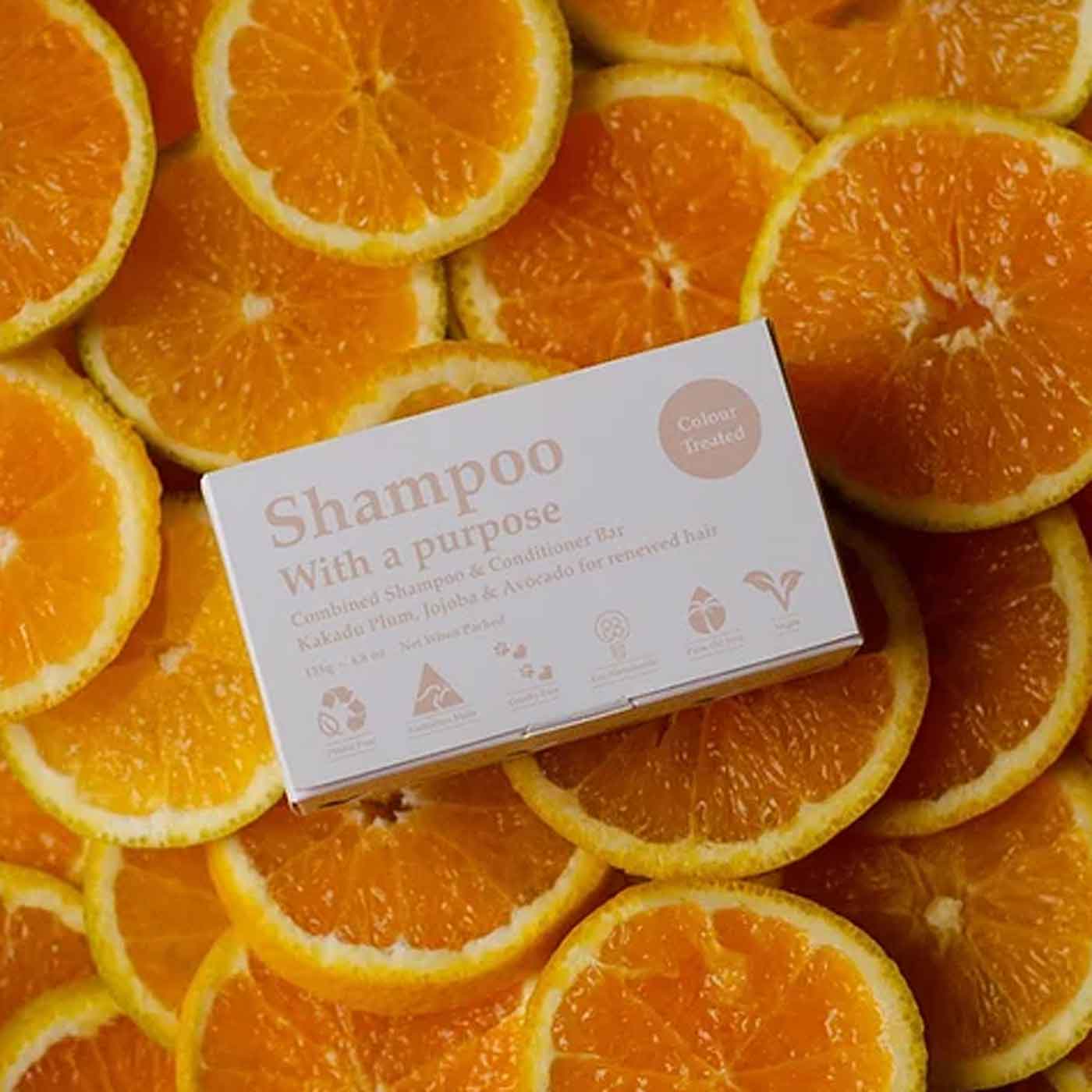 all natural zero-waste shampoo bar. Shampoo with a purpose for colour treated hair on orange slices. Diminish